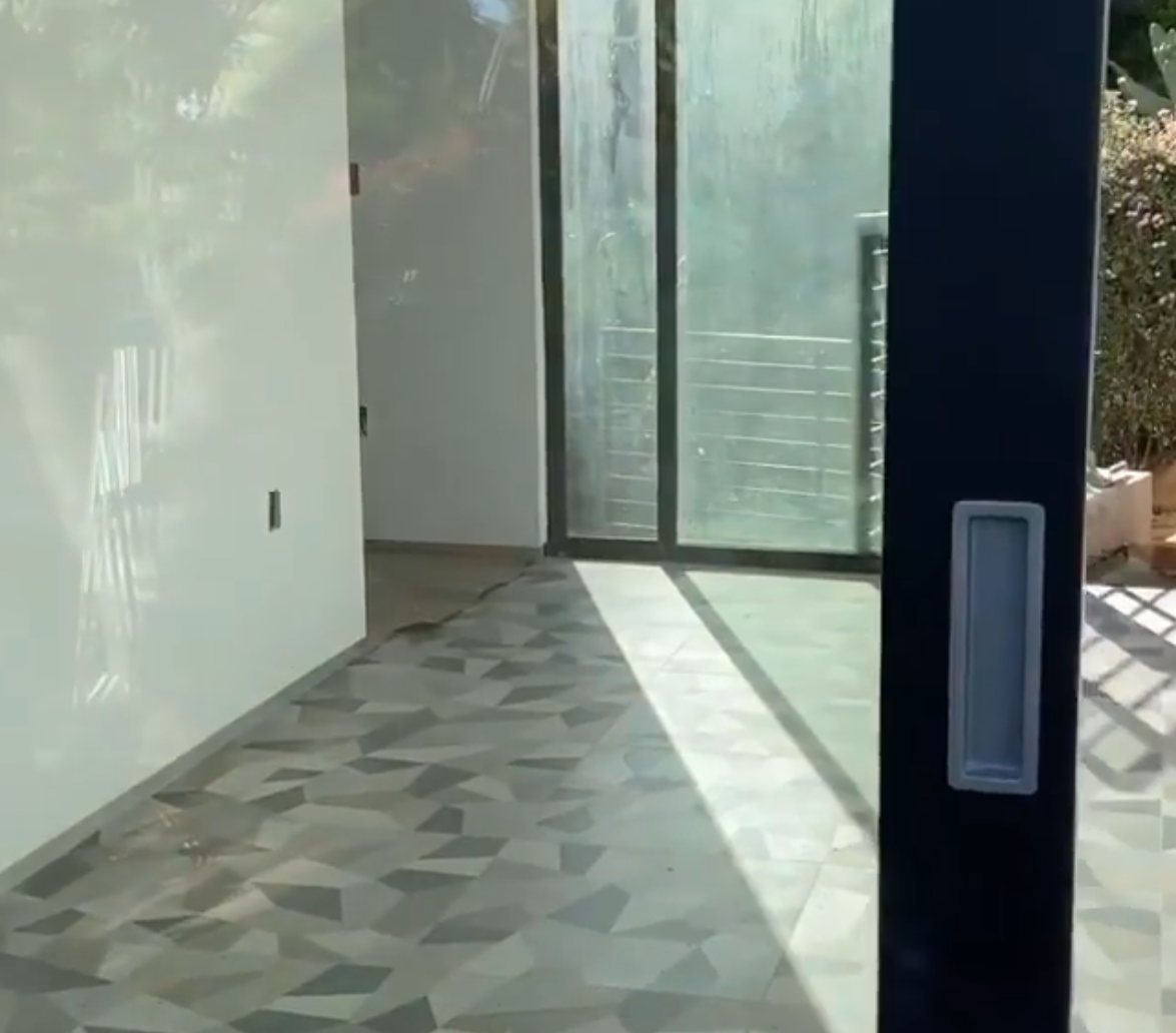 Interior with geometric gray tile floor and floor-to-ceiling sliding glass doors