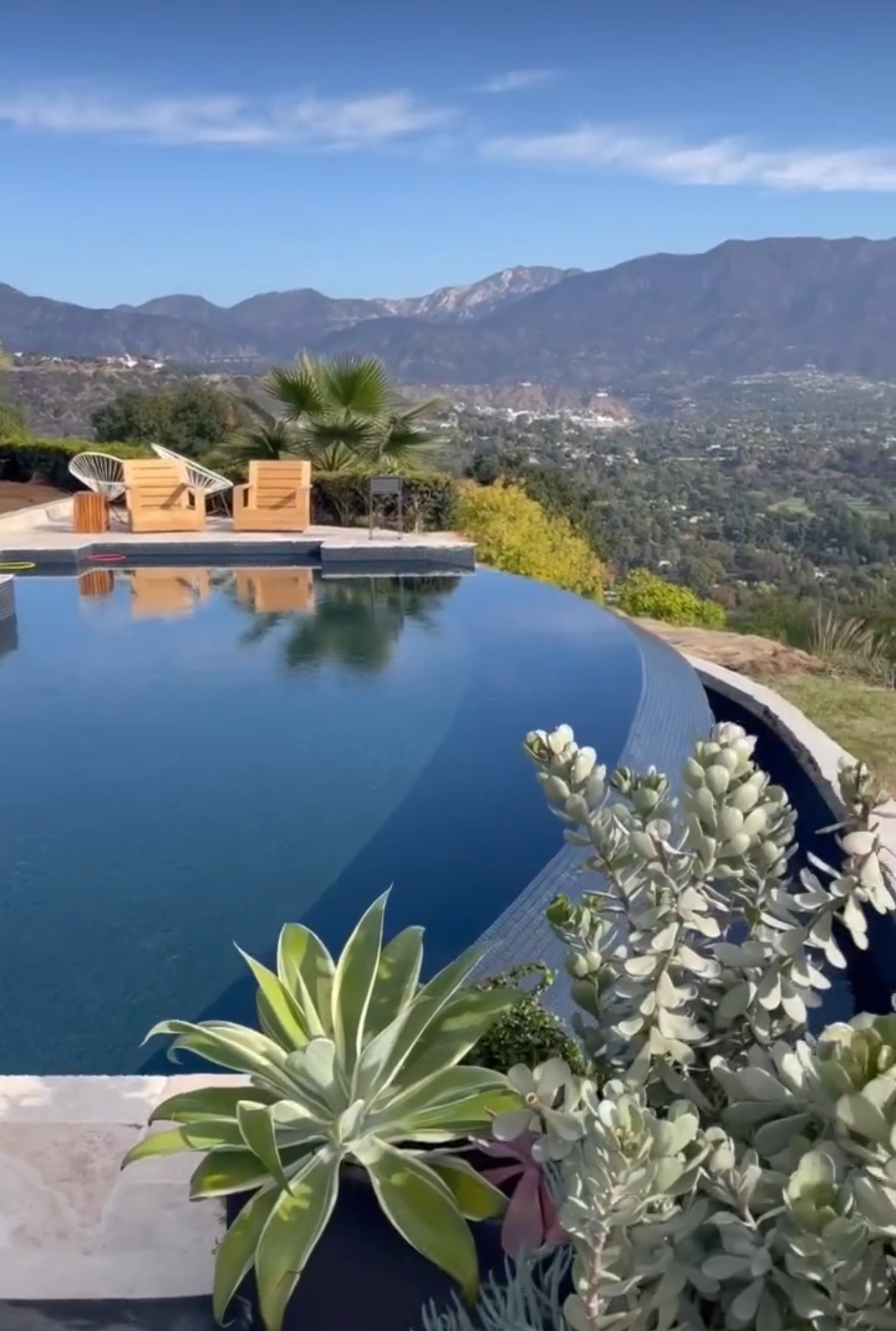 Infinity pool edge overlooking the San Gabriel Mountains, with agave and succulents