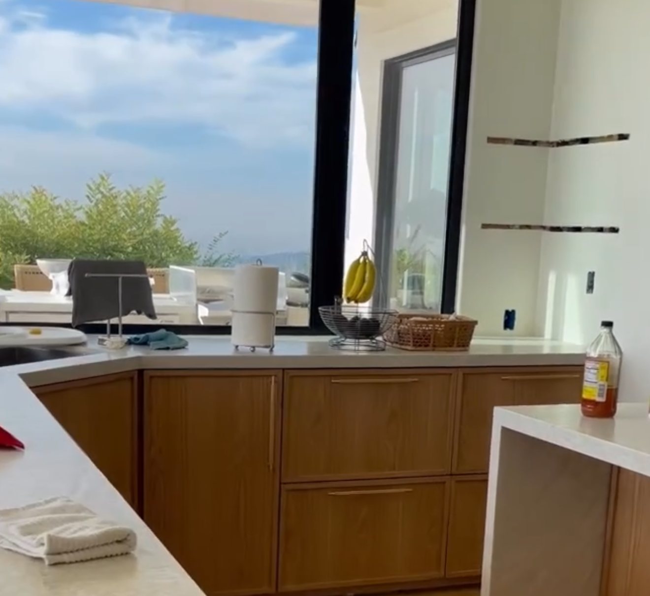Kitchen with oak cabinets, stone counters, and a large black-framed window