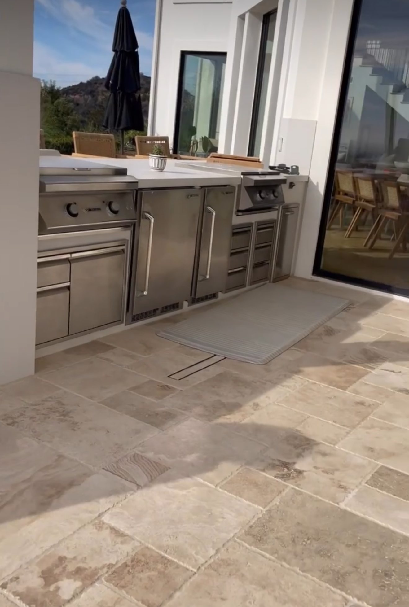 Stainless outdoor kitchen on a covered travertine patio