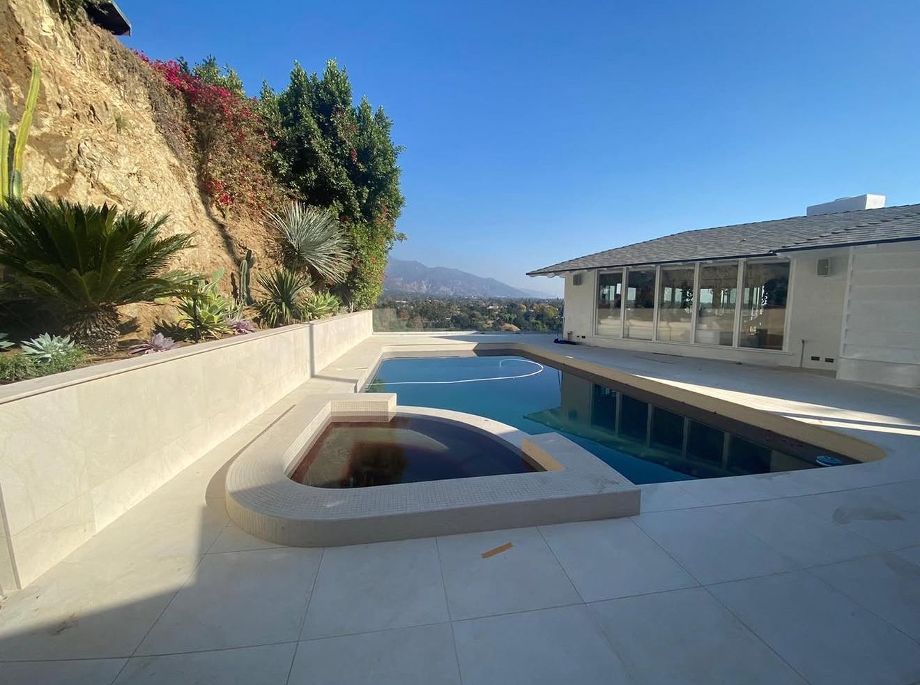 Pool deck with a stone-clad retaining wall against the hillside