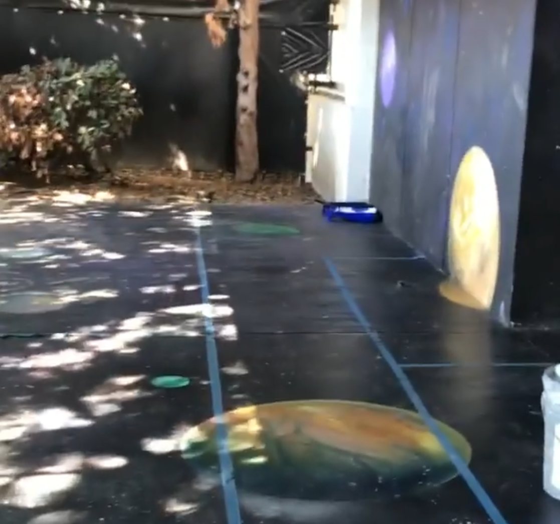 Solar-system design painted on a dark floor at Ad Astra School