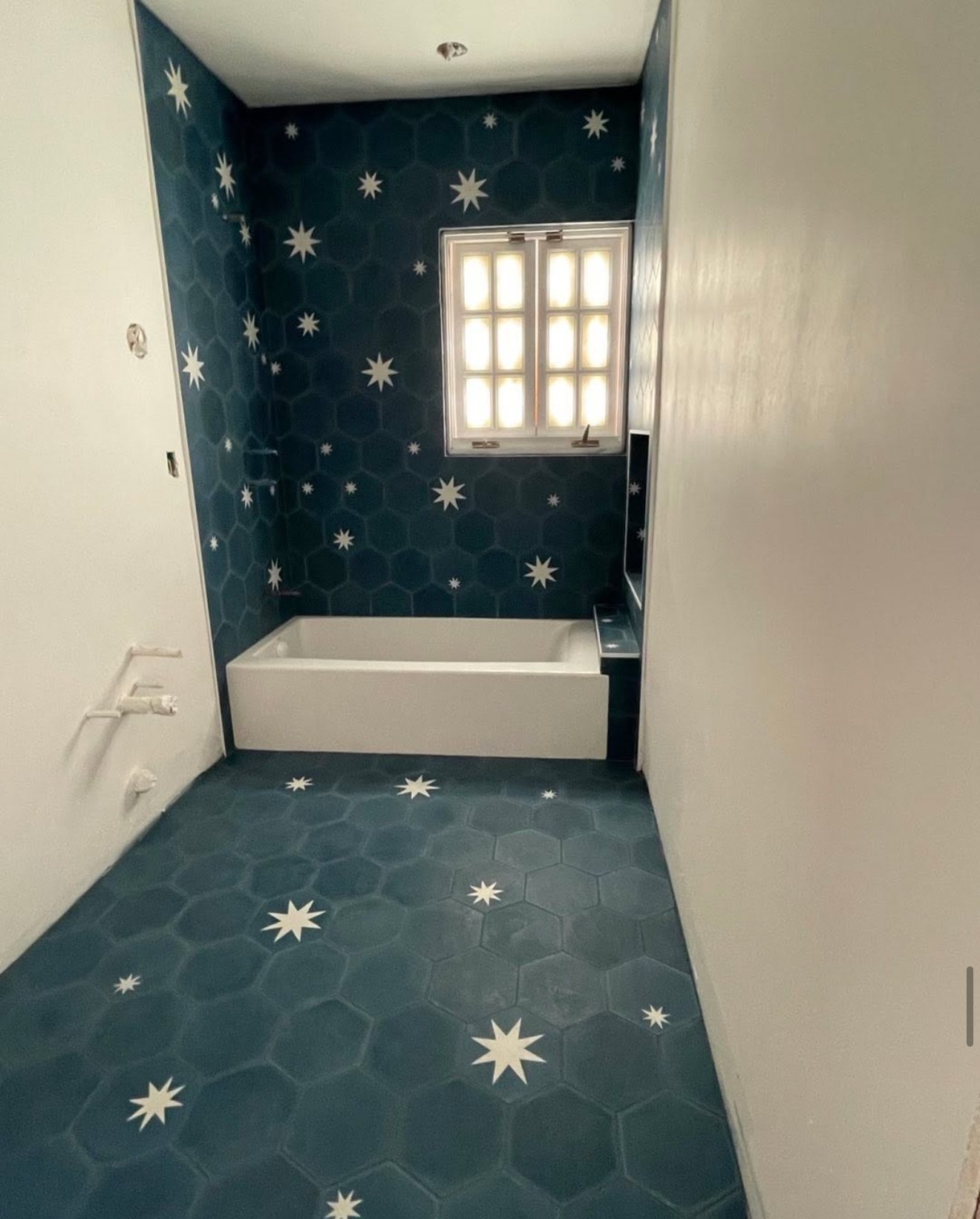 Bathroom with navy hexagon cement tile with white stars on floor and walls