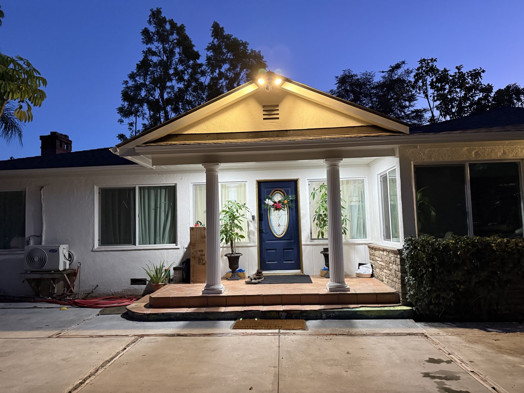 The finished home at dusk with porch lights on and a new concrete walk