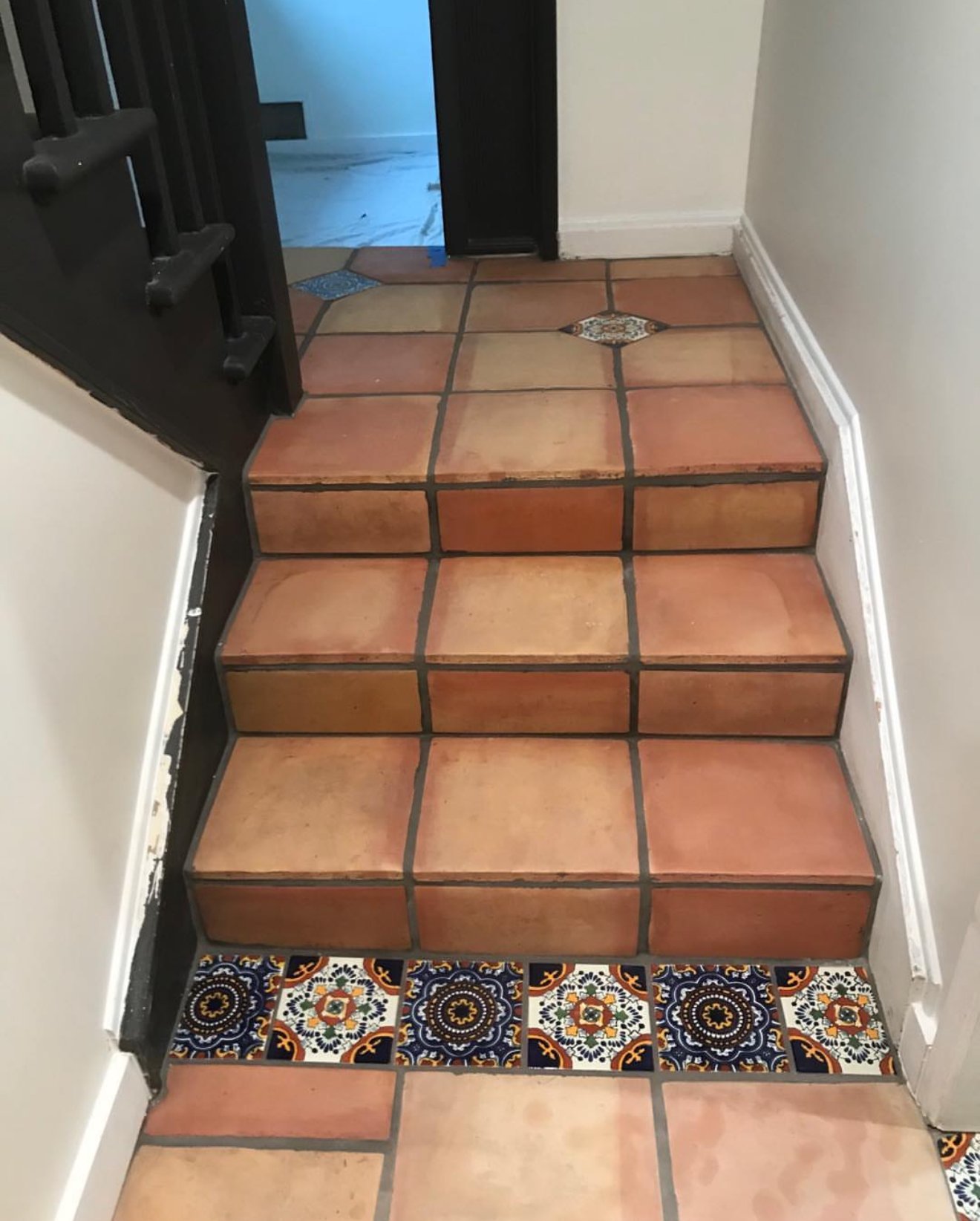 Saltillo tile stairs finished with a row of Talavera tiles